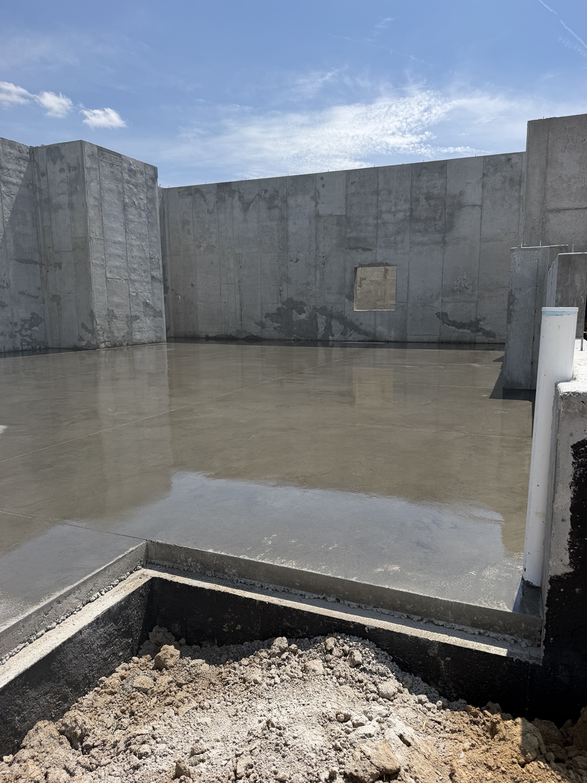 Fresh concrete floor inside foundation walls